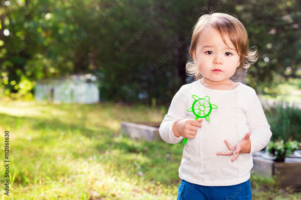 Happy toddler girl playing outside