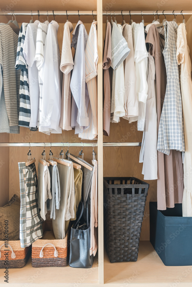 clothes and dress hanging on rail in wooden closet