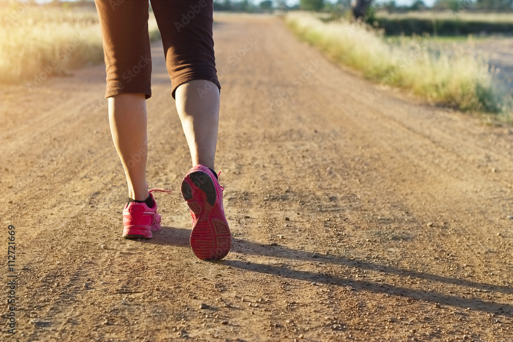 Woman walking exercise on trail in summer nature