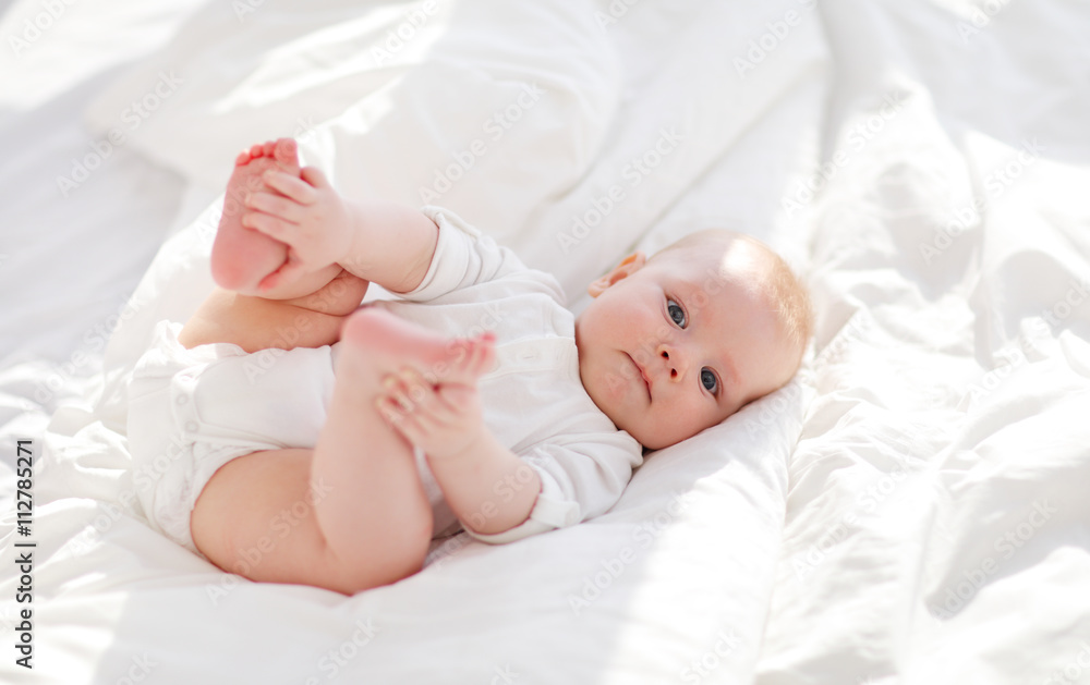 happy newborn baby on bed