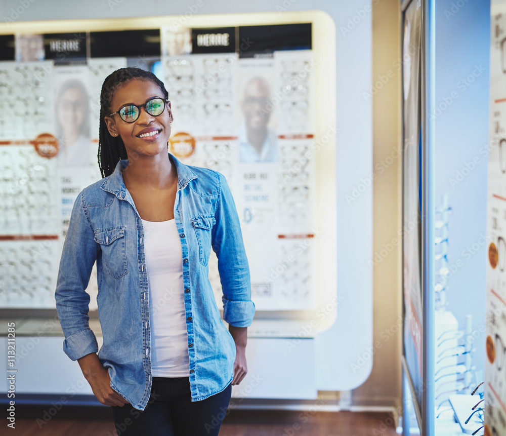 Smiling female in front of eyeglasses display