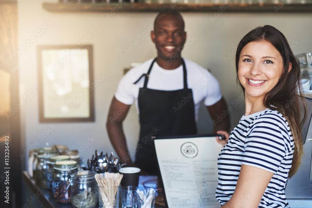 Cheerful customer with menu and cafeteria owner