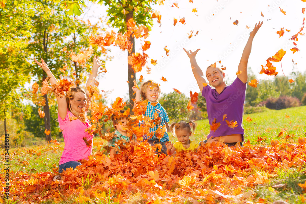 Family playing with leaves and throwing them