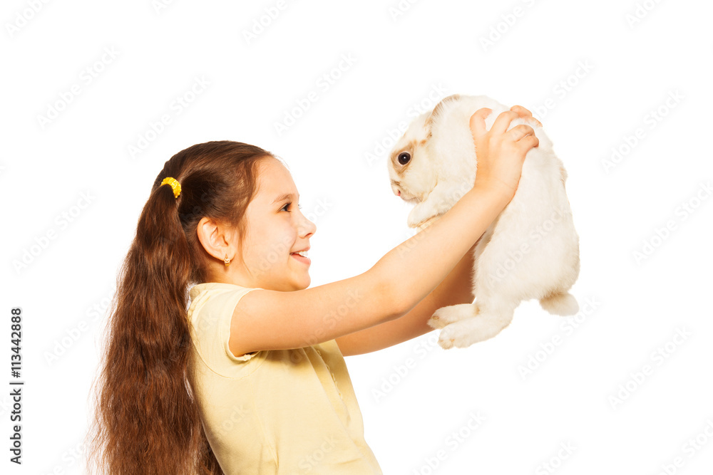 Happy little girl play with small white rabbit