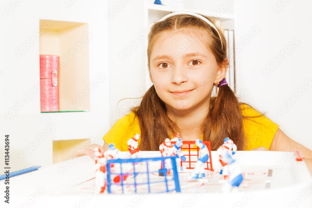 Beautiful girl playing ice hockey table board game