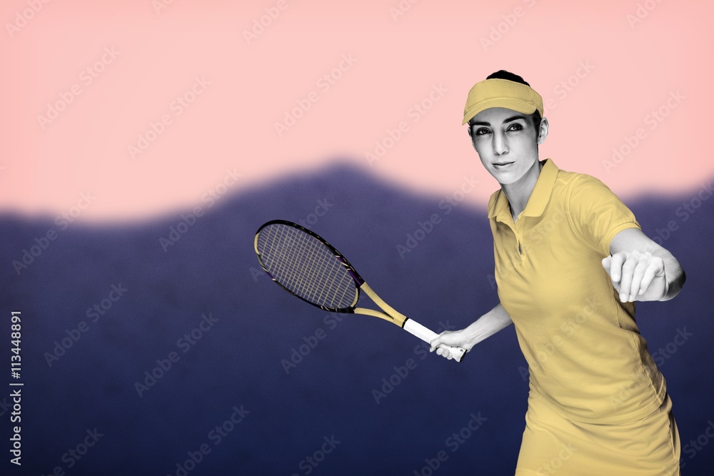 Female athlete playing tennis against blurred mountains