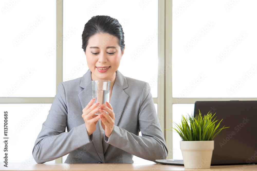 Young asian businesswoman holding glass of water