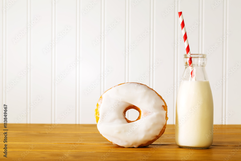 White glazed donut with jar of milk