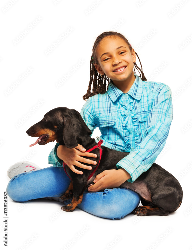 Smiling African girl hugging black dachshund 