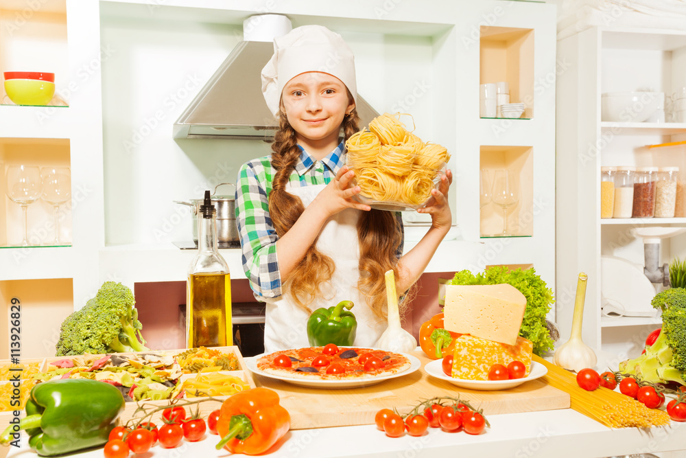 Girl in cooks uniform making Italian pasta