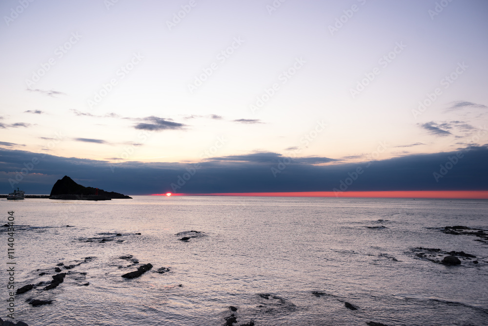 rock beach near tranquil sea at sunrise