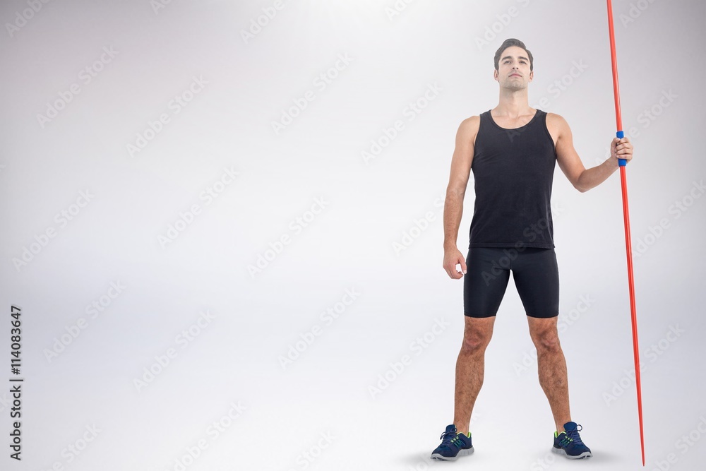 Composite image of confident male athlete holding javelin