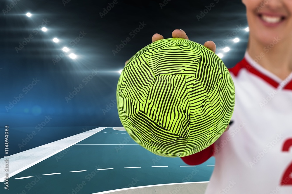 Composite image of sportswoman holding a ball