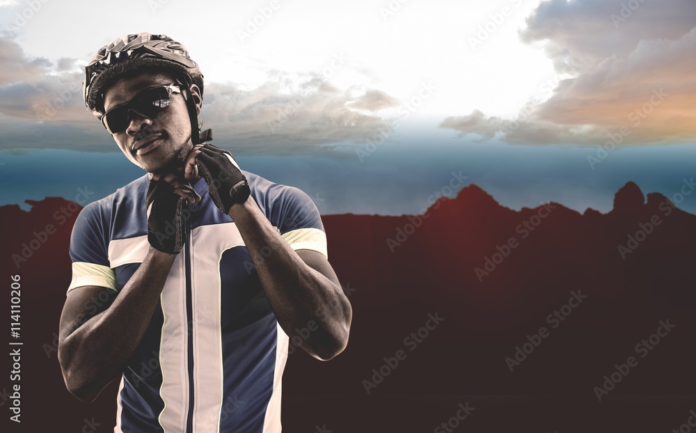 Composite image of athletic man putting his cycling helmet