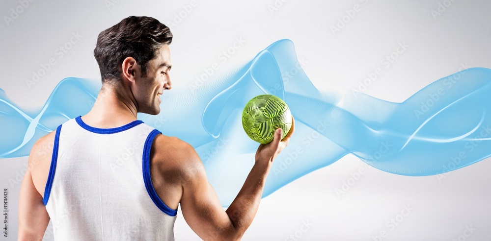 Composite image of happy athlete male holding a ball 