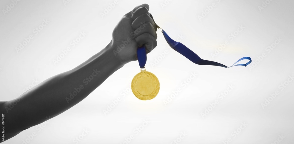 Hand holding a gold medal on white background