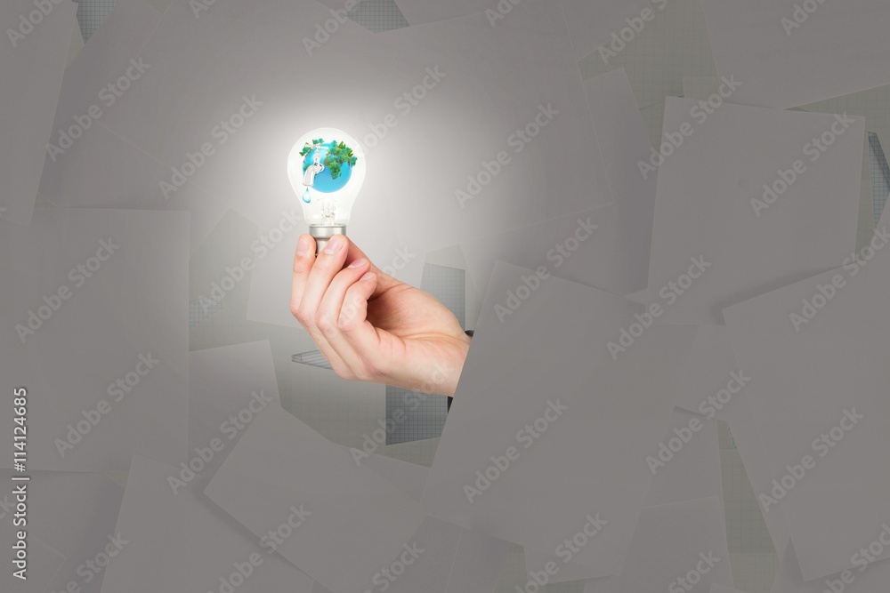 Composite image of hand holding environmental light bulb