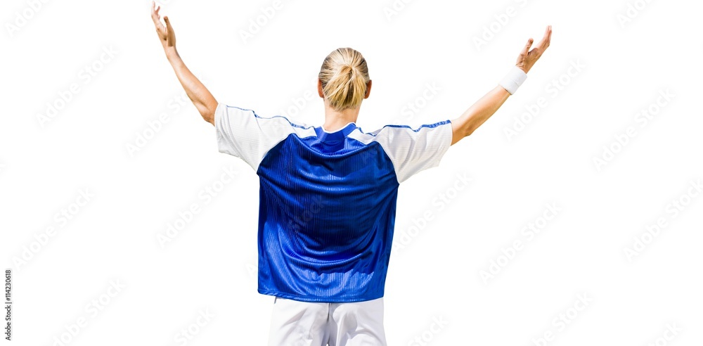 Rear view of sportswoman raising arms 