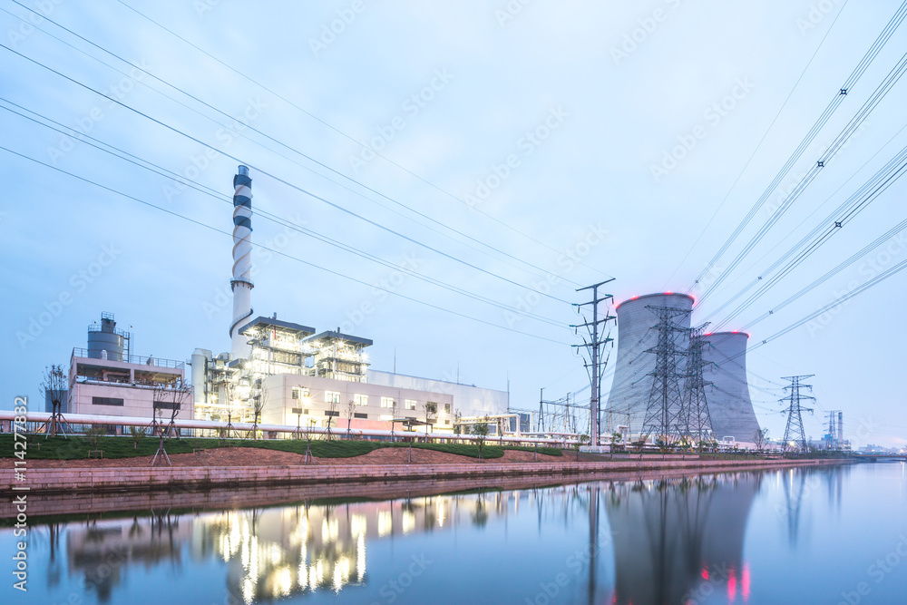 modern factory near river in blue sky at dawn