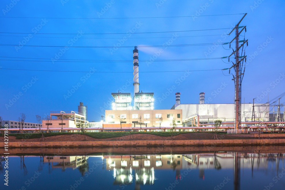 modern factory near river in blue sky at dawn