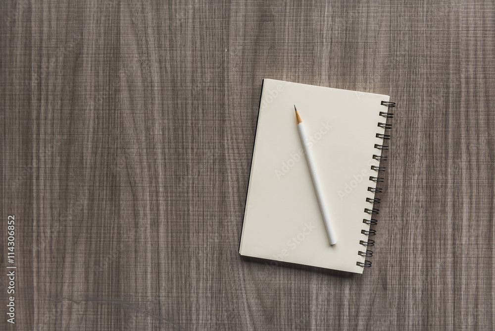 white pencil with blank notebook