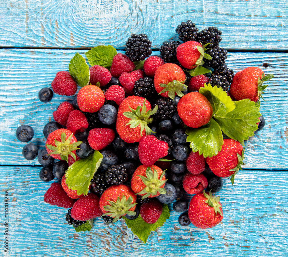 Fresh berry fruit pile placed on old wooden planks