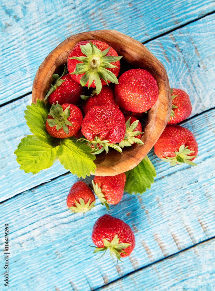 Strawberries in saucer, placed on old wooden planks