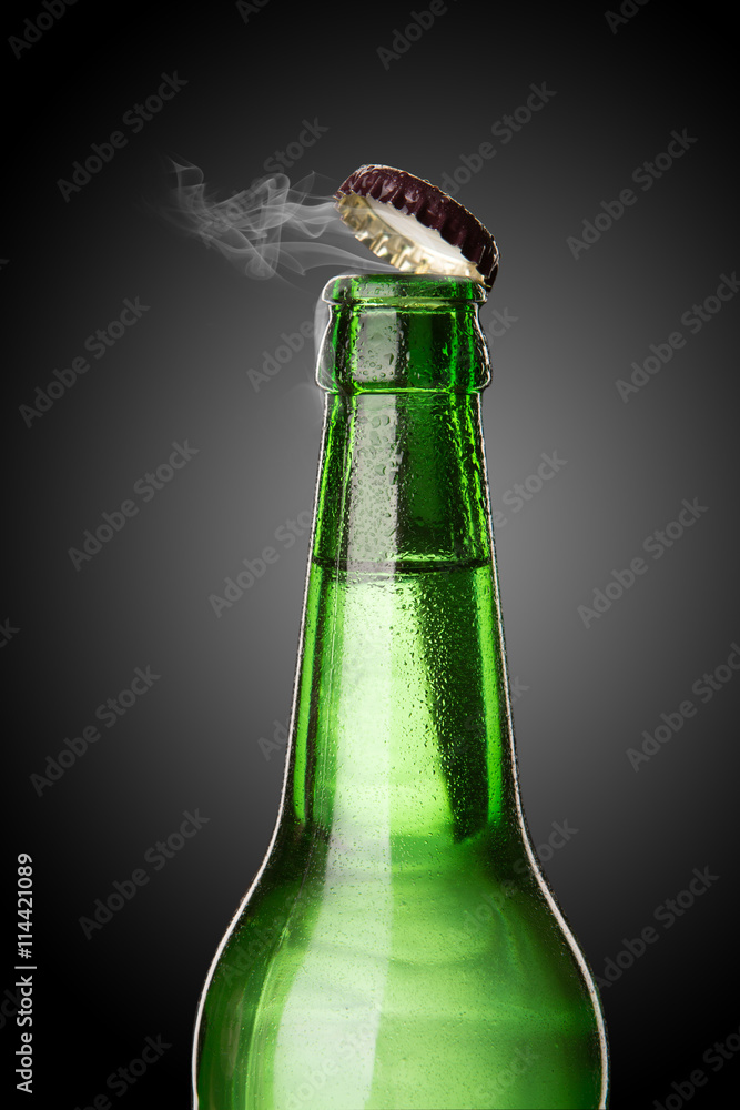 Cold wet beer bottle with frost and vapor