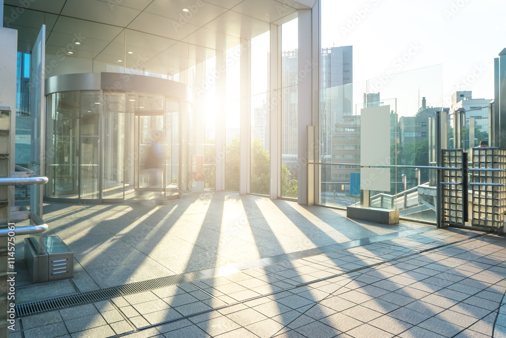 empty footpath through modern office buildings in tokyo with sun