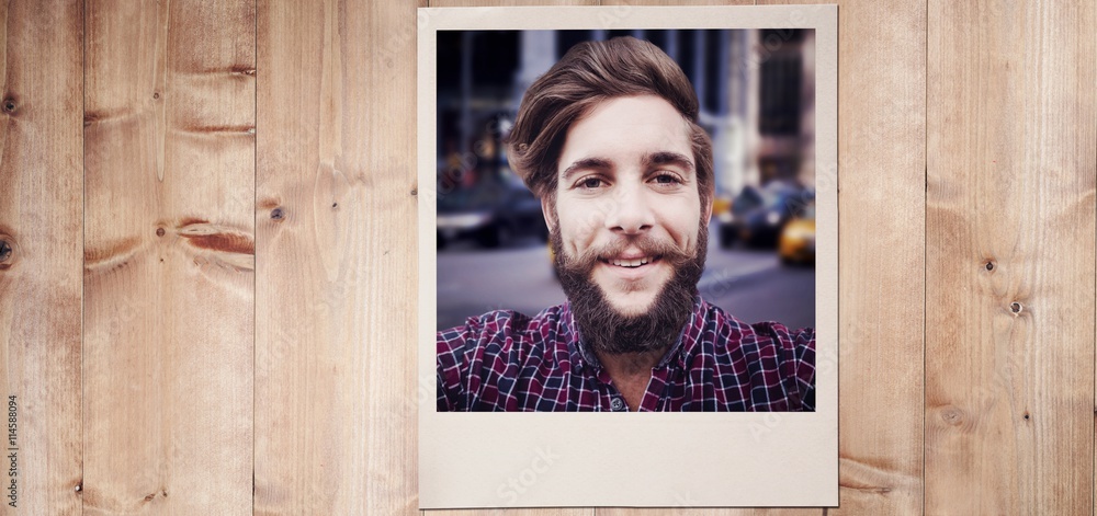 Composite image of happy hipster against wooden fence