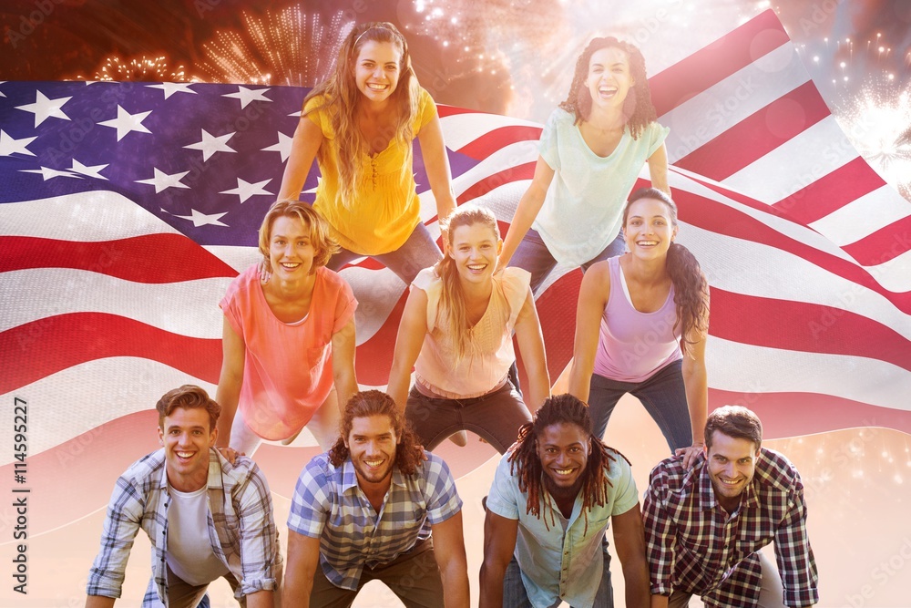 Composite image of happy friends making human pyramid