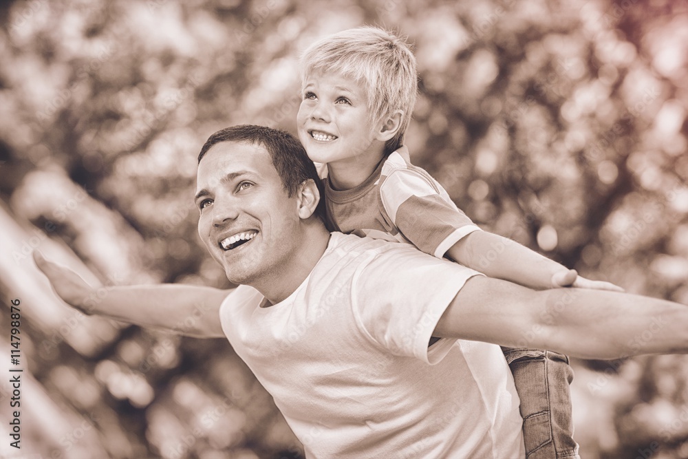 Son playing with his father in the park during the summer 