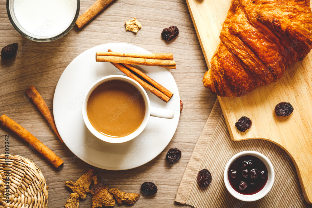 Breakfast with coffee and croissants on wooden table top view