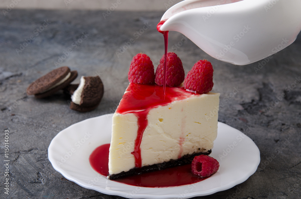 Piece of cheesecake with Oreo cookies and raspberries