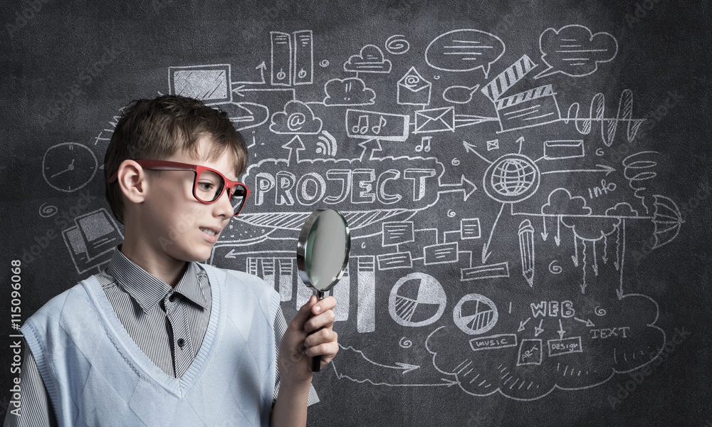 Curious school boy with magnifier