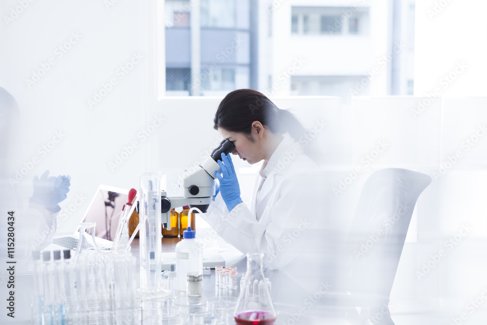 Woman looking through a microscope in a laboratory