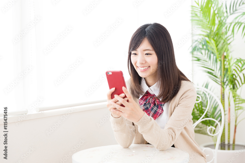 asian schoolgirl using smart phone in the cafe