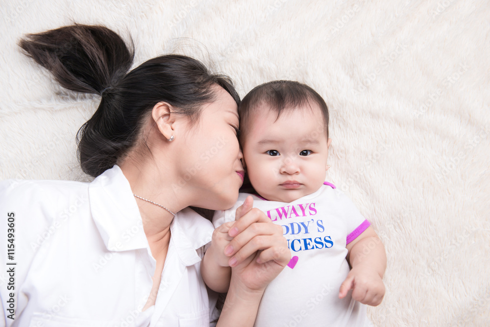 Portrait of beautiful mom playing with her 6 months old baby 