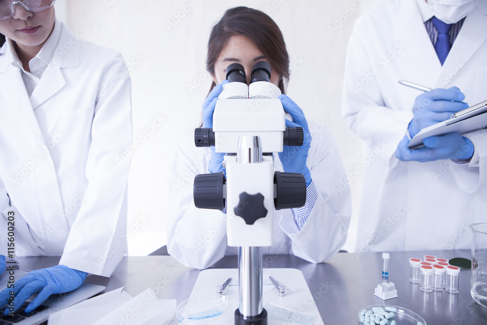 Female researcher looking through a microscope