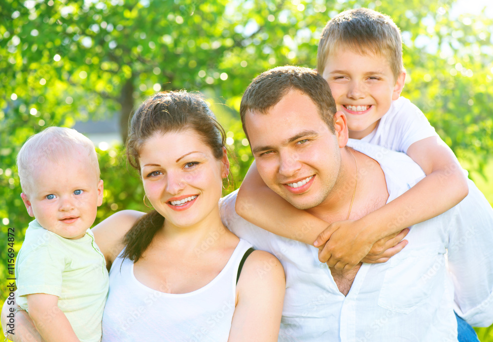 Happy joyful young family together in summer park