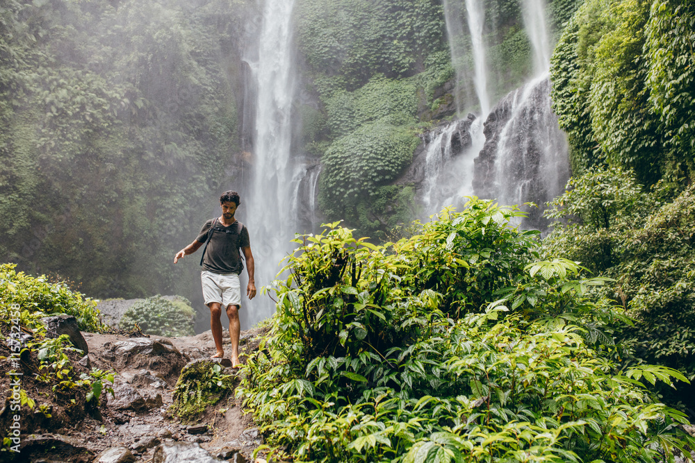 Young man walking along mountain trail