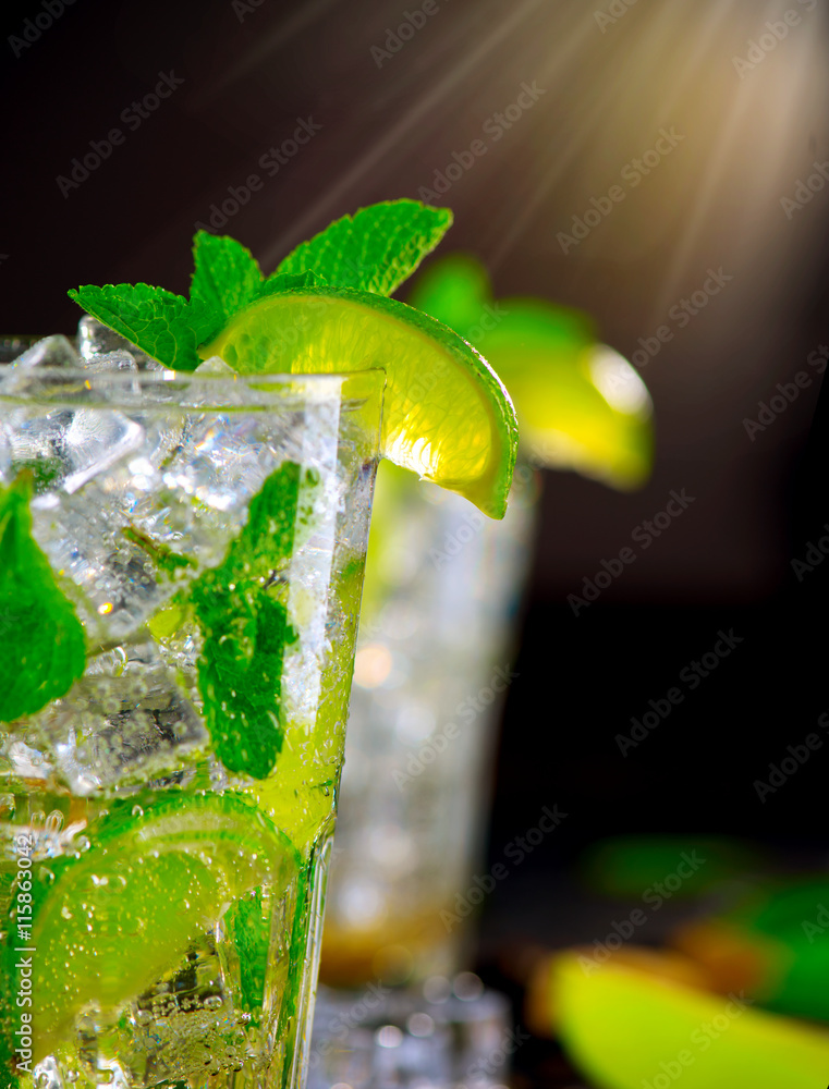 Mojito cocktail on a table. Summer cocktail with rum, lime, mint, ice cubes and brown sugar