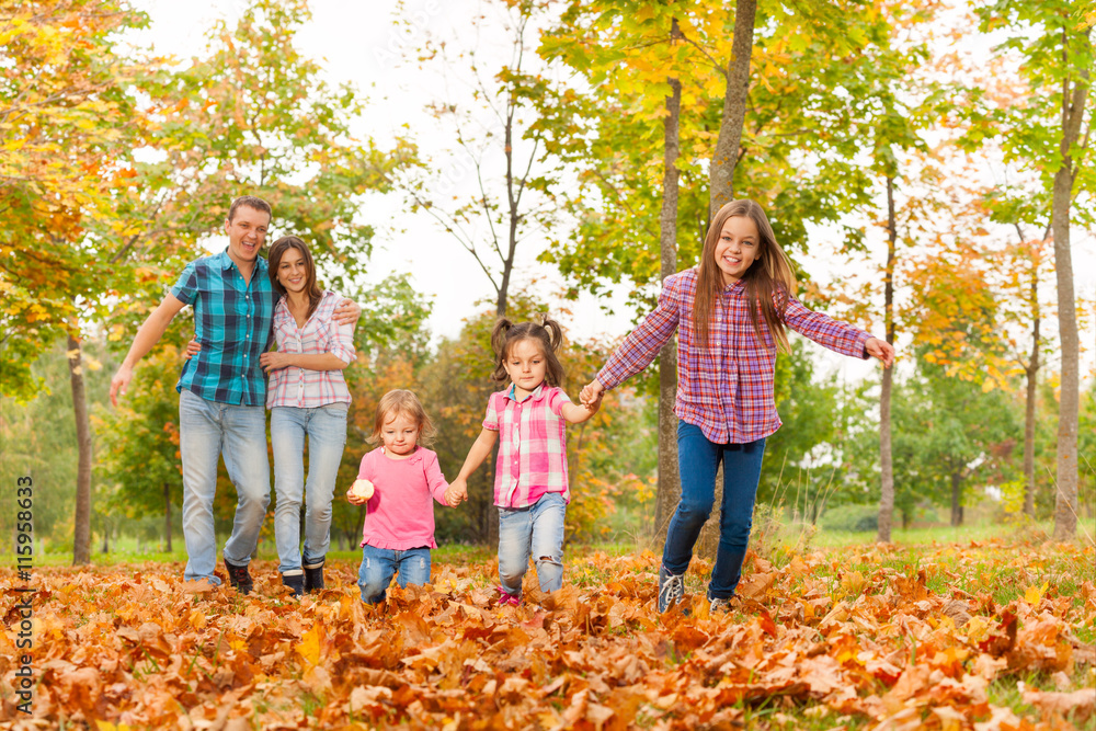 Parents walk in the park with little girls