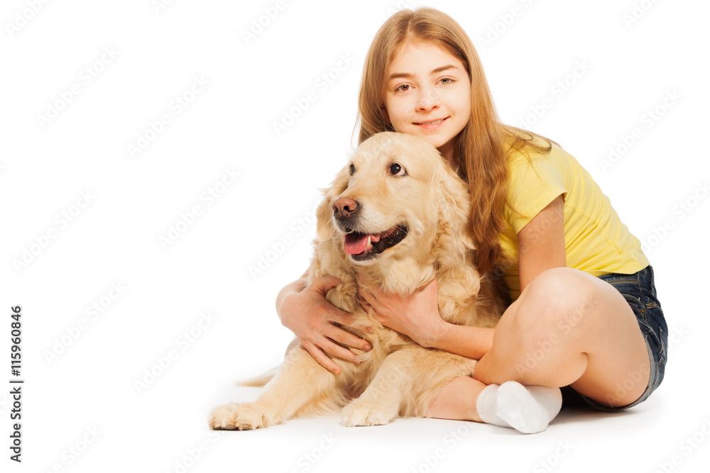 Smiling teenage girl sitting with Golden Retriever