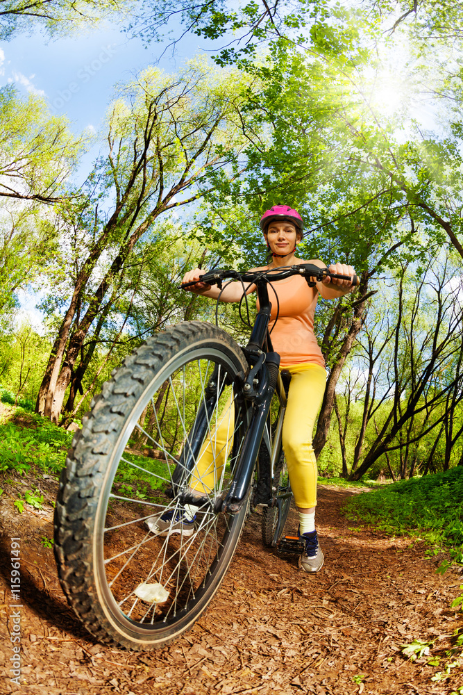 Woman riding a mountain bike on forest trail