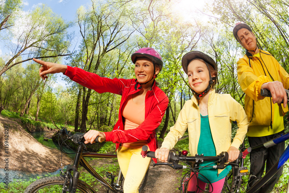 Happy active family with bikes finding their way