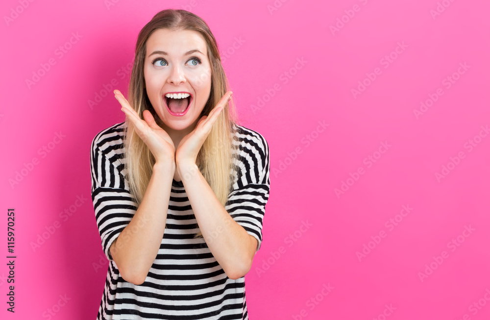 Happy young woman posing on pink background