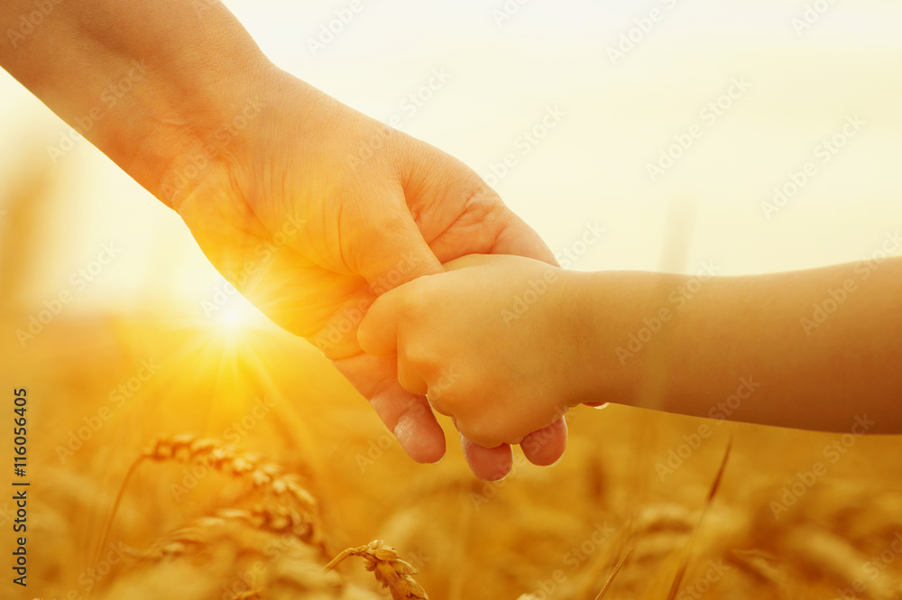 Hands of mother and daughter on sun