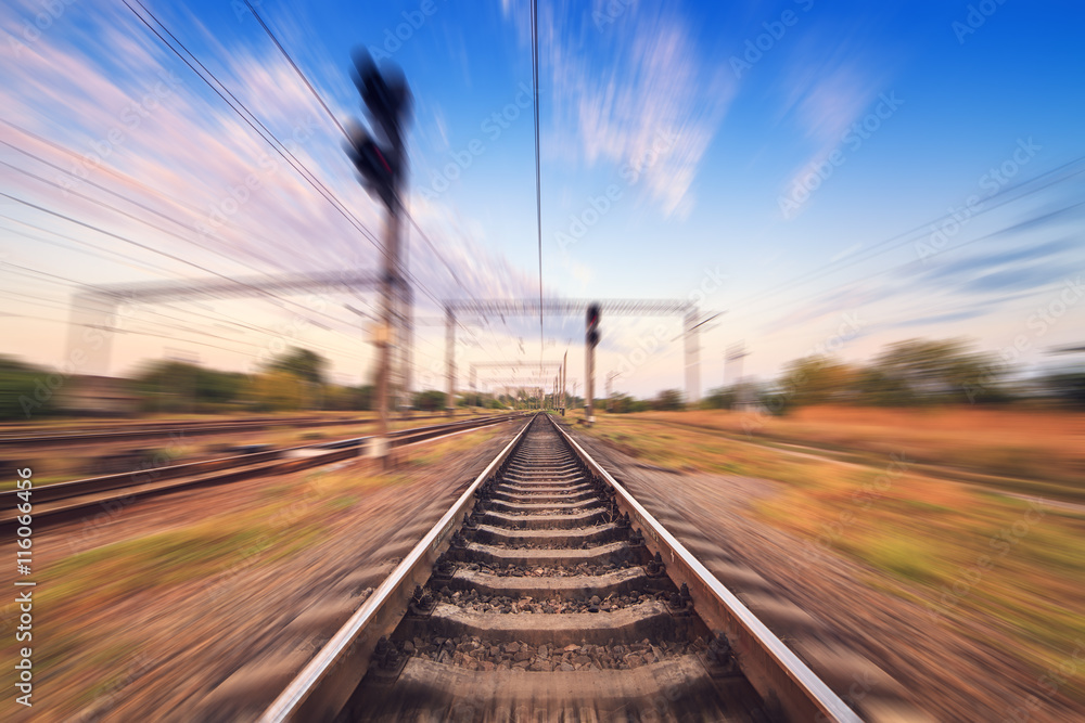 Railway station at colorful sunset with motion blur effect. Rail