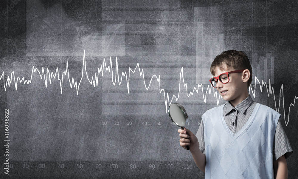 Curious school boy with magnifier